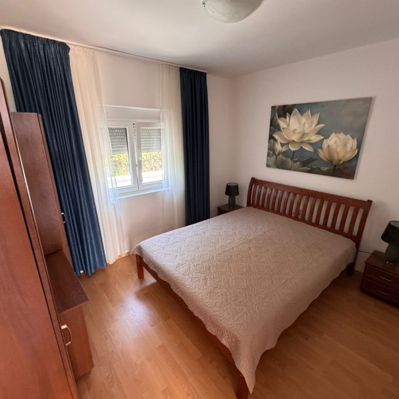 Elegant Ulcinj bedroom for sale: wood bed, luxe beige quilt, top finishes. Invest with Montenegro-listings.me by Ekosphere doo.