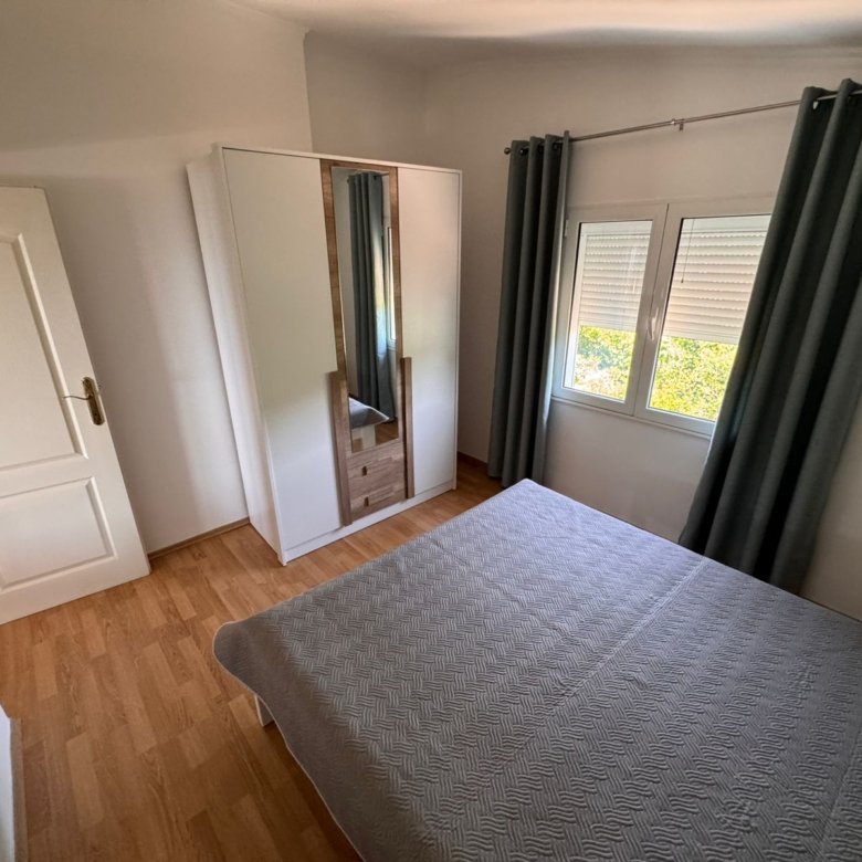 Stylish Ulcinj bedroom: wooden flooring, gray bed, mirrored wardrobe. Invest in prime Montenegro real estate by Ekosphere on immorenta.me.
