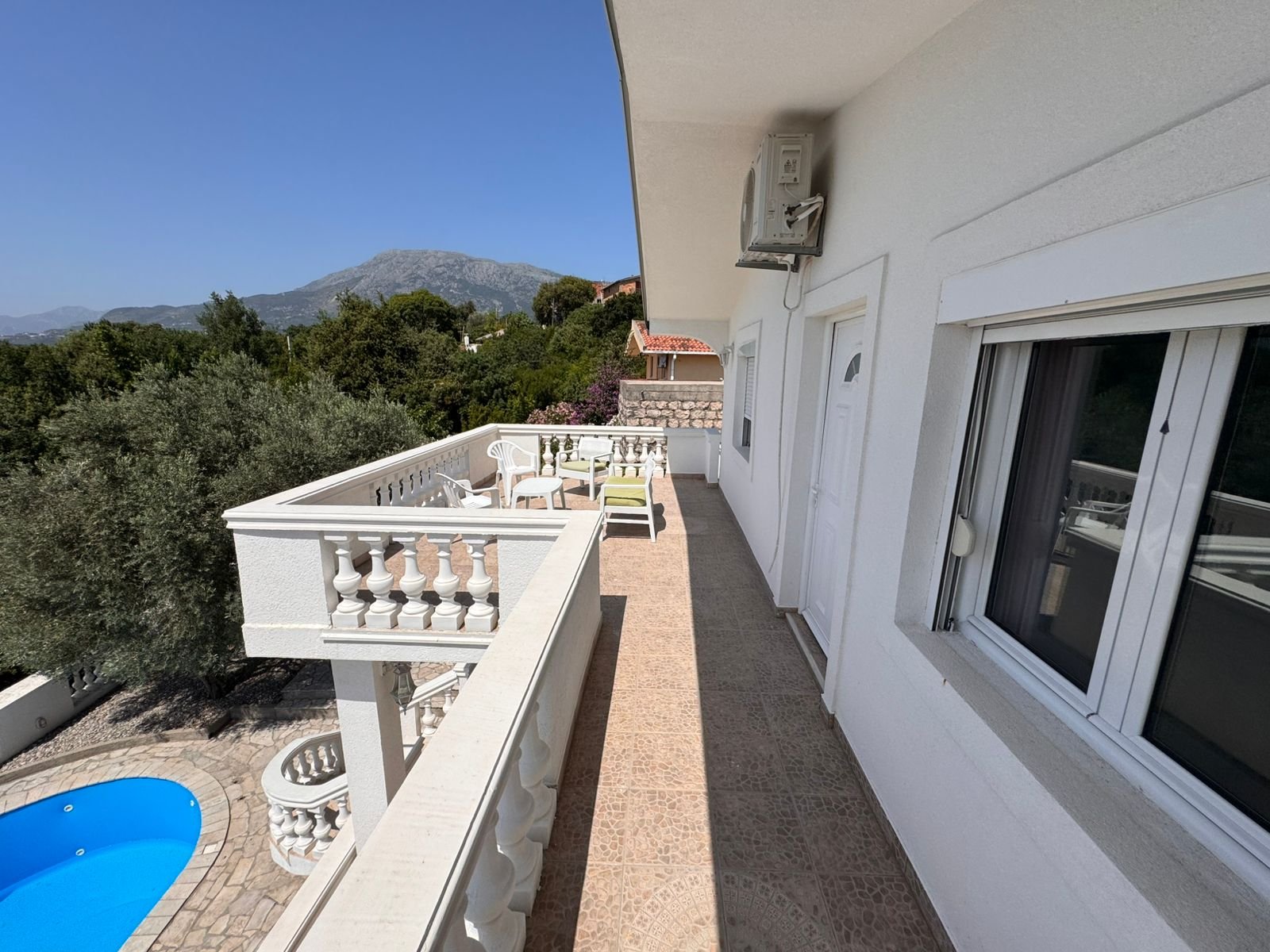 Elegant white balcony with tiled floor, pool view, scenic mountains&mdash;prime Ulcinj real estate by Ekosphere DOO at immorenta.me.