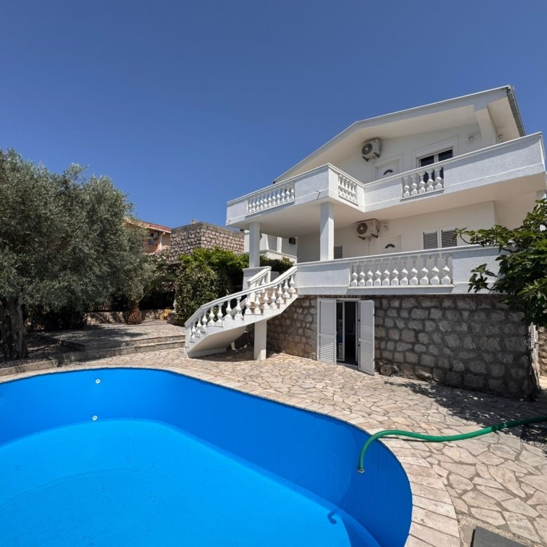 Elegant two-story white home with balconies, stone accents, pool & curved stairs&mdash;prime Ulcinj real estate by Ekosphere on immorenta.me.