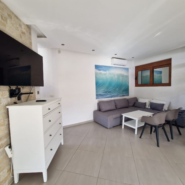 Elegant Ulcinj living room with gray sectional, white accents, and modern art. Ideal investment&mdash;exclusive on immorenta.me by ekosphere doo.