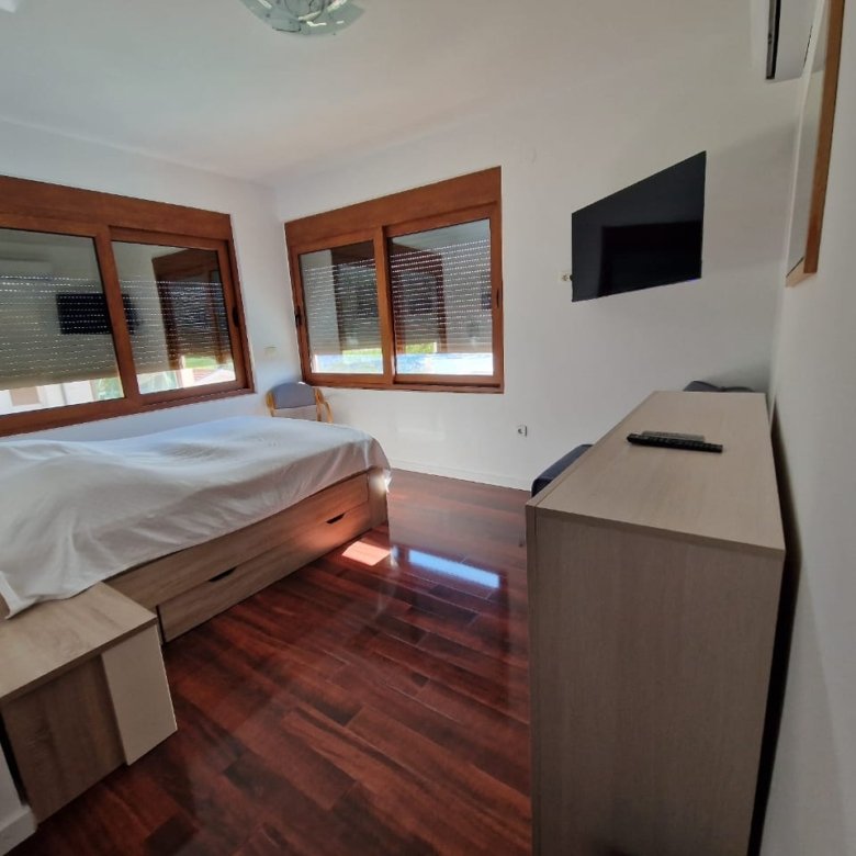 Modern Ulcinj bedroom with double bed, sleek furnishings & large windows&mdash;premium real estate by Ekosphere on immorenta.me.