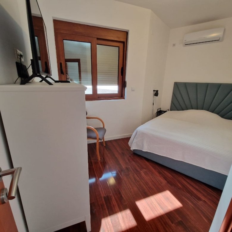 Stylish Ulcinj bedroom with double bed, wood floor, AC, and modern comforts&mdash;prime property by Ekosphere on immorenta.me.