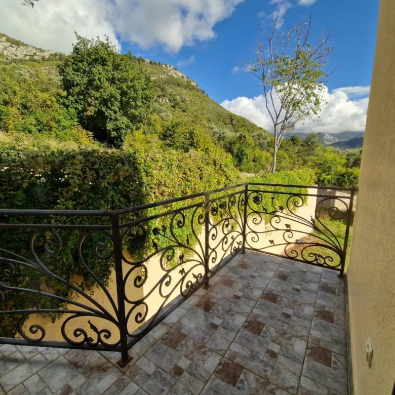 Elegant tiled balcony with ornate railing, lush garden views, and rolling hills&mdash;prime Ulcinj real estate on immorenta.me by ekosphere doo.