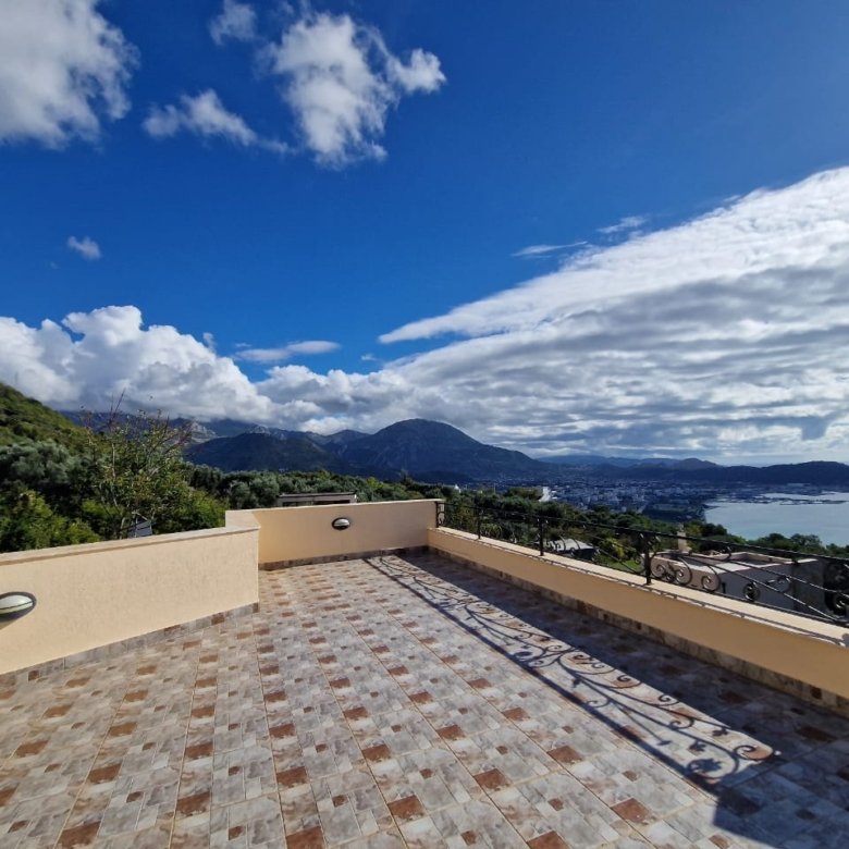 Luxury tiled terrace with yellow railing, panoramic sea, town, and green hill views&mdash;prime Ulcinj real estate by ekosphere doo.