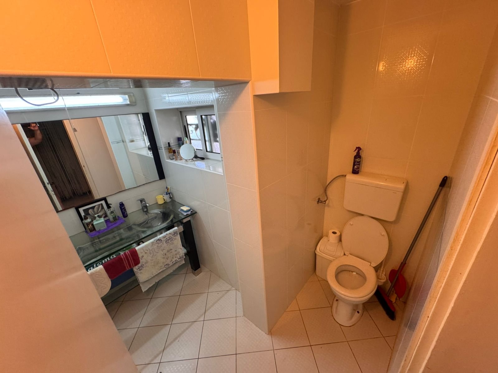 Modern Ulcinj bathroom with beige tiles, glass sink, and large mirror&mdash;prime real estate at immorenta.me by Ekosphere doo.