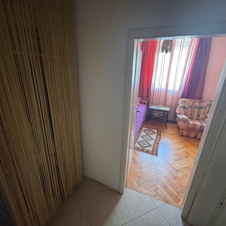 Stylish Ulcinj apartment: tiled hallway, beige string curtain, parquet living room. Prime property by Ekosphere on immorenta.me.