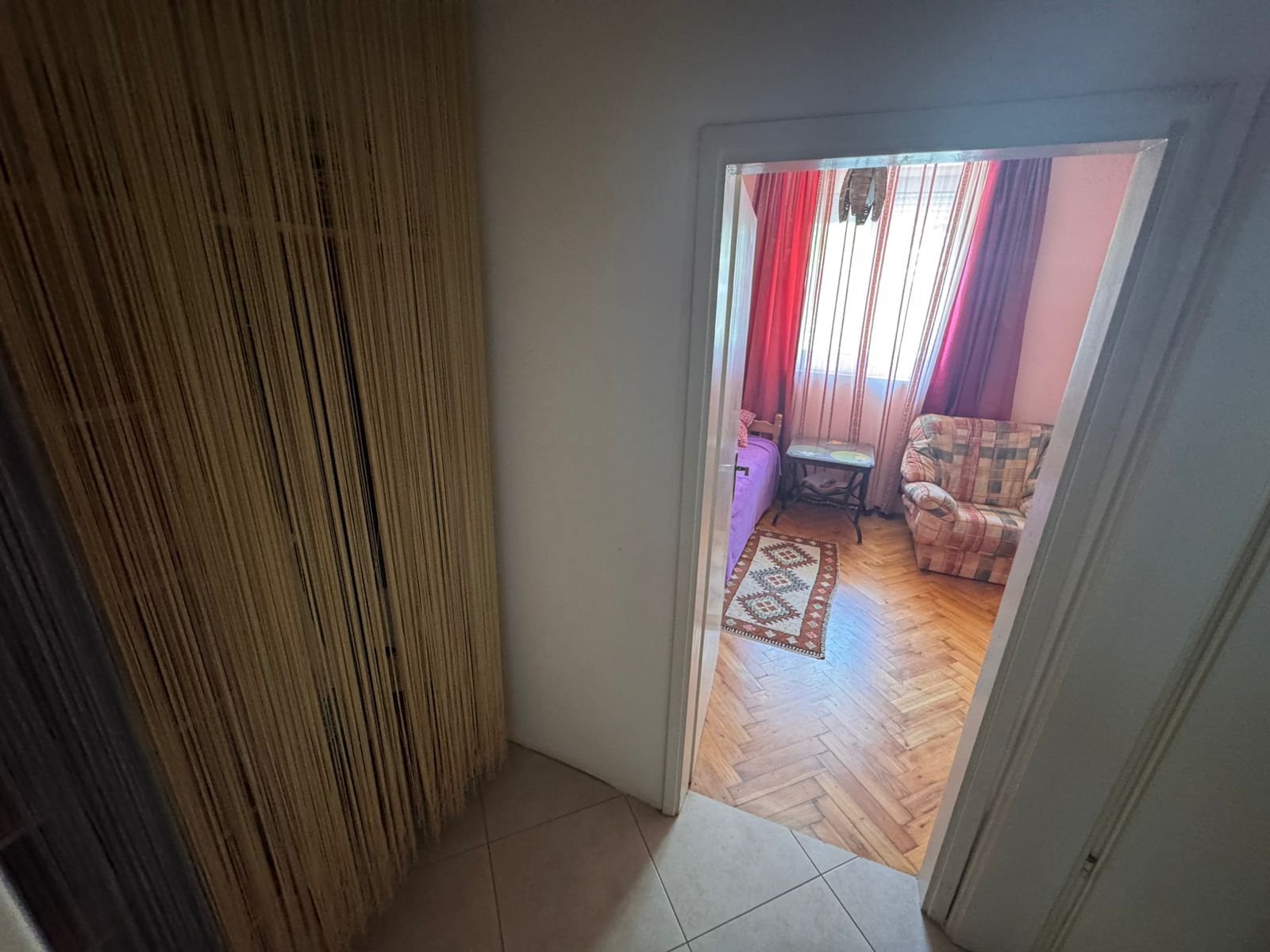 Stylish Ulcinj apartment: tiled hallway, beige string curtain, parquet living room. Prime property by Ekosphere on immorenta.me.