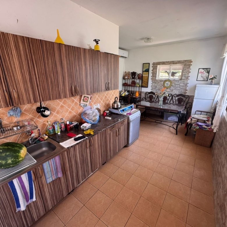 Charming Ulcinj kitchen with wood cabinets, tiled backsplash, and open sitting area&mdash;exclusive at immorenta.me by ekosphere doo.