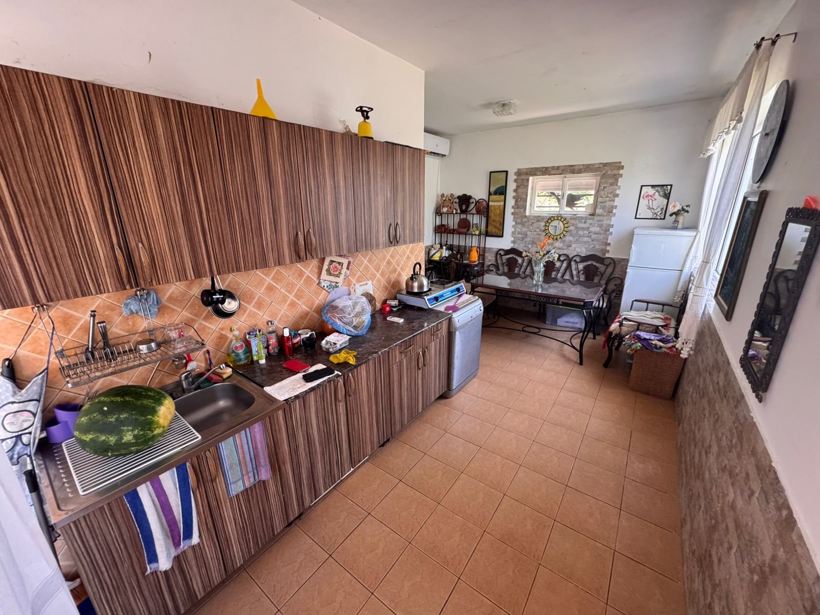 Charming Ulcinj kitchen with wood cabinets, tiled backsplash, and open sitting area&mdash;exclusive at immorenta.me by ekosphere doo.