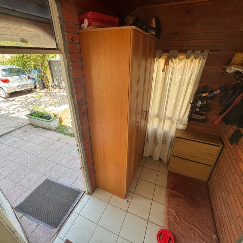 Bright entryway with tiled floors, brick accents, and storage furniture in Ulcinj home; direct driveway access. eksosphere doo project.