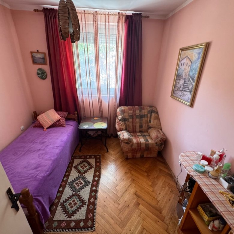 Charming Ulcinj bedroom: pink walls, single bed, armchair, window; ideal Montenegro investment on immorenta.me by ekosphere doo.