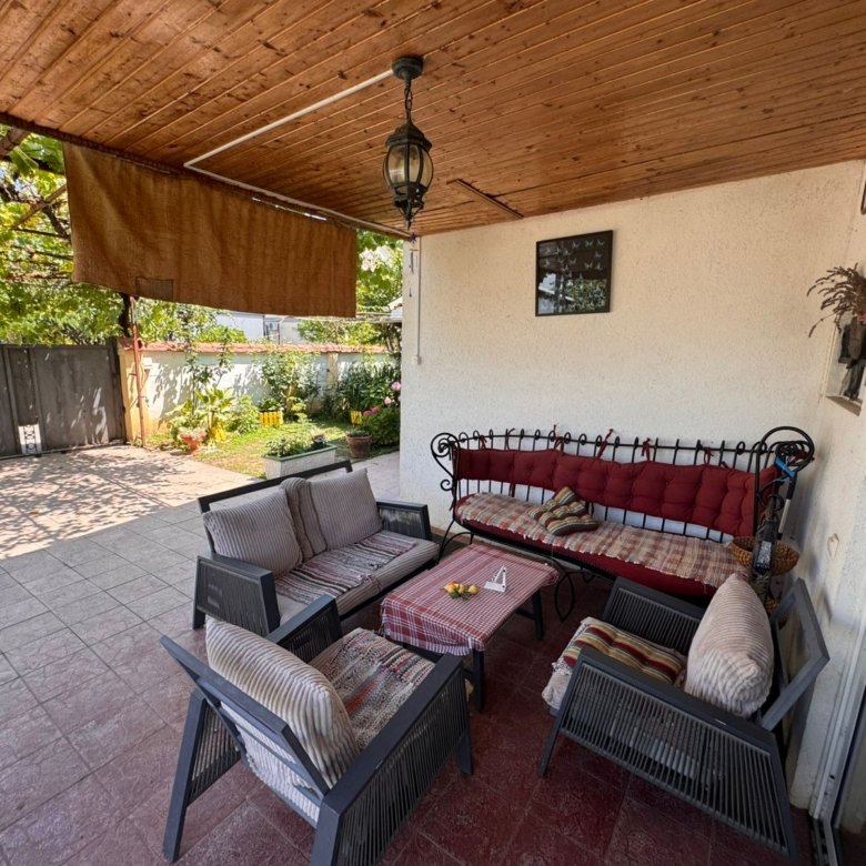 Spacious covered patio with cushioned seating, garden views, and stylish decor&mdash;prime Ulcinj Montenegro real estate by ekosphere doo.