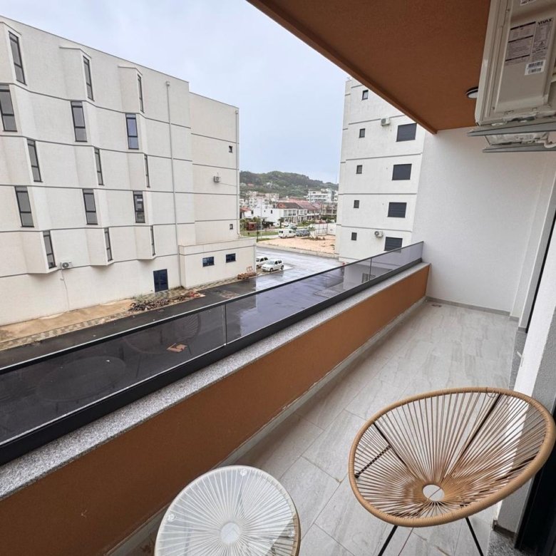 Stylish Ulcinj apartment balcony with street view, AC, and modern lounge set&mdash;ideal investment. Listed by immorenta.me (ekosphere doo).
