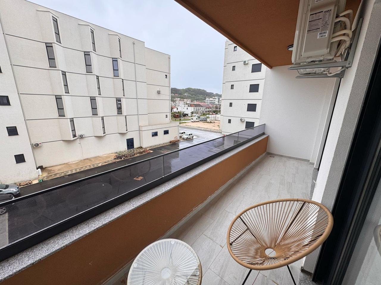 Stylish Ulcinj apartment balcony with street view, AC, and modern lounge set&mdash;ideal investment. Listed by immorenta.me (ekosphere doo).