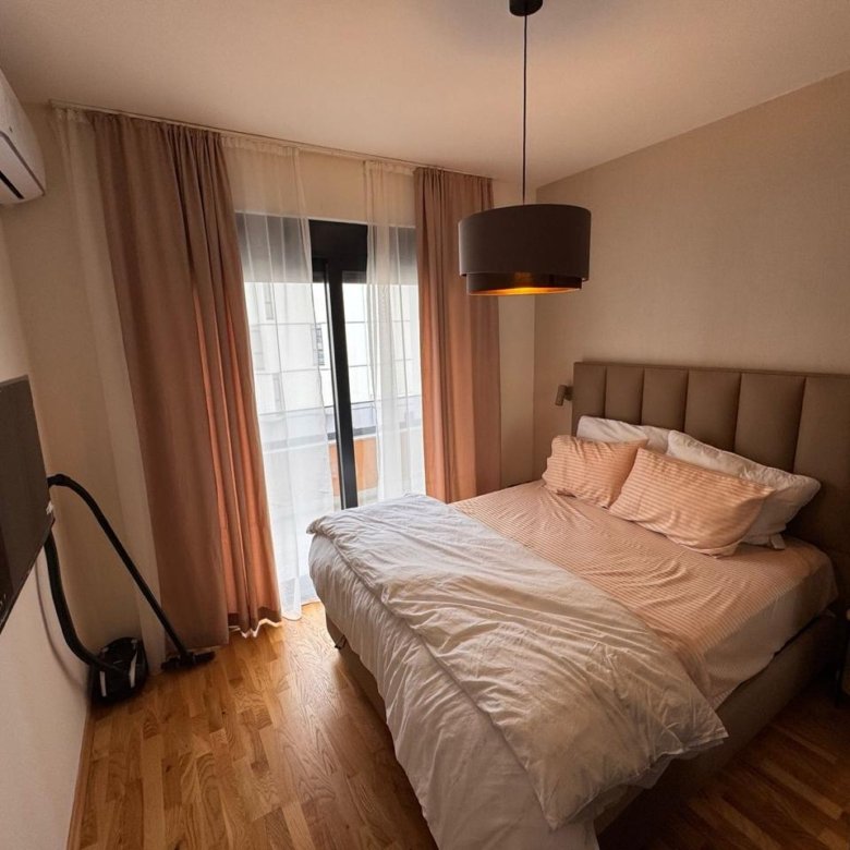 Modern bedroom in Ulcinj with balcony, double bed, and amenities; prime real estate from immorenta.me by ekosphere doo.