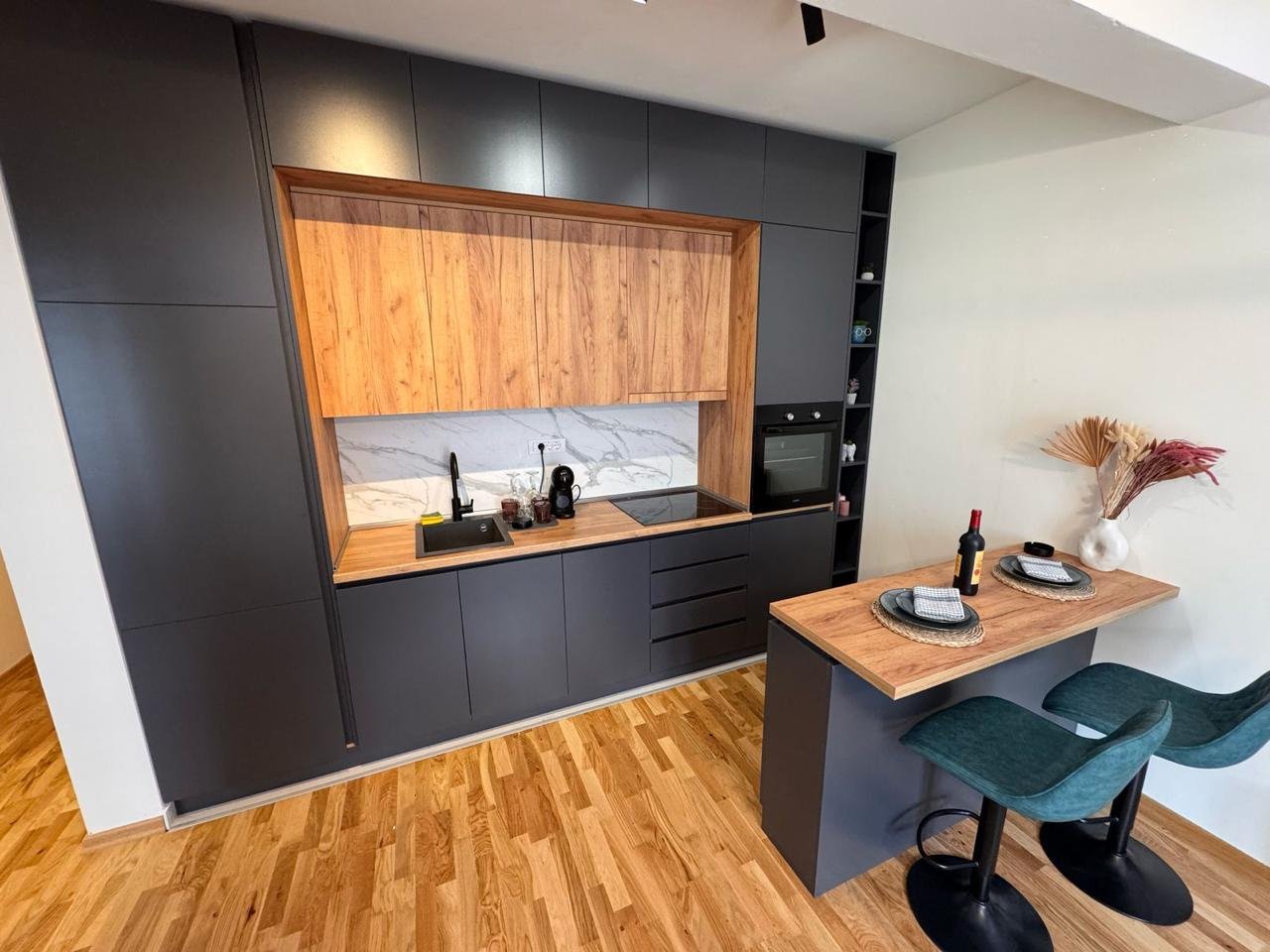 Luxury modern kitchen in Ulcinj, Montenegro: sleek black cabinets, marble backsplash, built-ins&mdash;exclusive at immorenta.me by ekosphere doo.