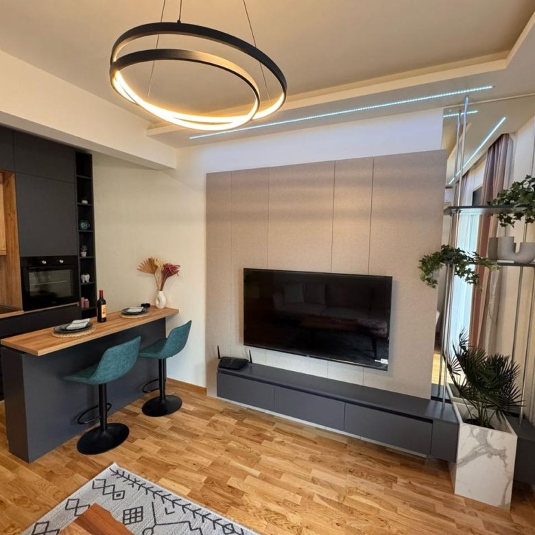 Stylish Ulcinj apartment with wood floors, island, teal barstools & sleek kitchen&mdash;investment on immorenta.me by ekosphere doo.