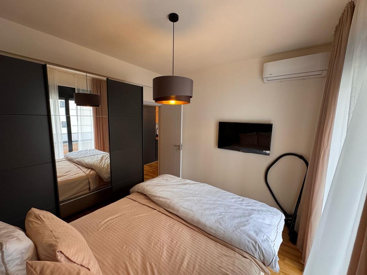 Modern Ulcinj bedroom: beige bedding, black wardrobe, AC, TV. Prime investment via immorenta.me by ekosphere doo.