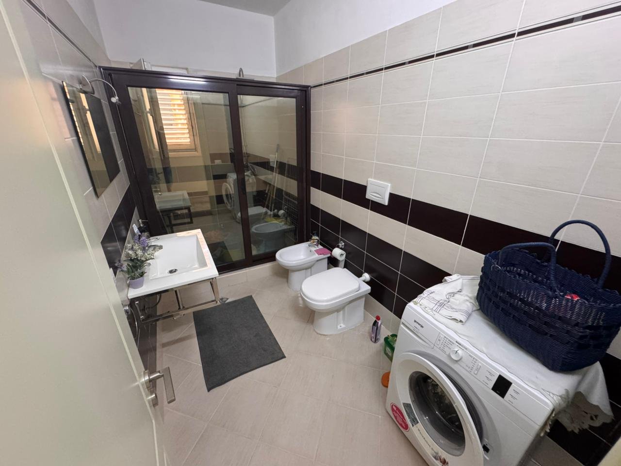 Modern bathroom in Ulcinj, Montenegro: elegant tiled walls, glass shower, bidet, premium fixtures; exclusive at immorenta.me by Ekosphere doo.