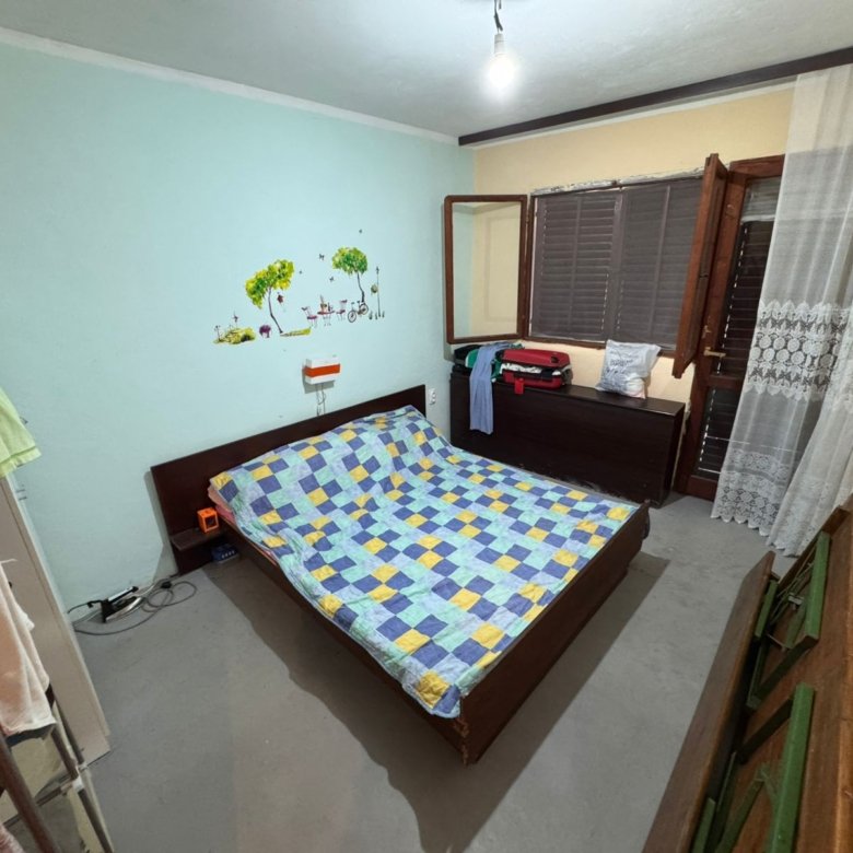 Charming Ulcinj bedroom with double bed, bright quilt, storage dresser & open window. Ideal Montenegro property by Ekosphere on immorenta.me.