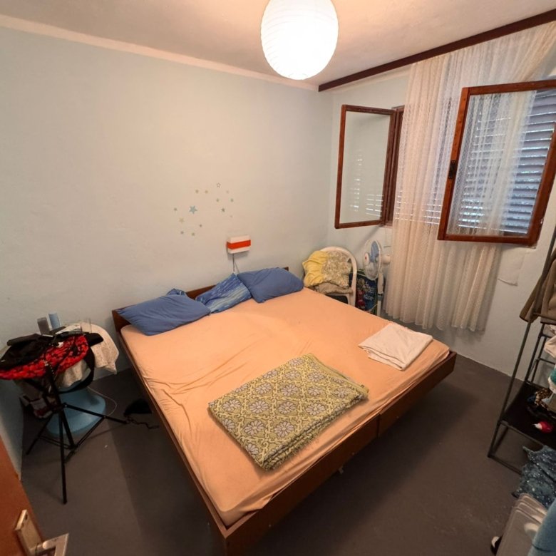 Charming Ulcinj bedroom with double bed, blue pillows, airy window&mdash;ideal real estate investment via immorenta.me by ekosphere doo.