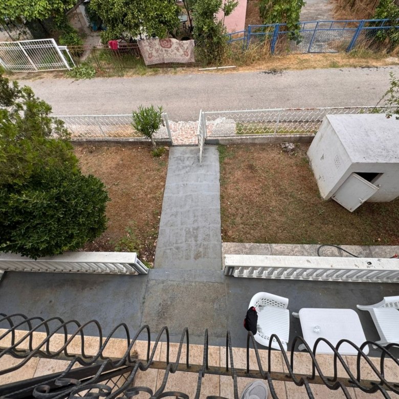 Upper balcony view in Ulcinj: private yard, stone path, white shed. Invest with immorenta.me, a project of Ekosphere doo.