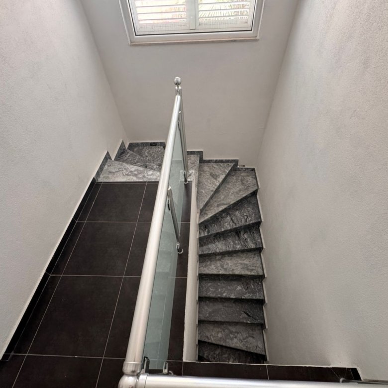 Elegant Ulcinj property: dark marble staircase with glass railing, white walls, exclusive listing on immorenta.me by ekosphere doo.