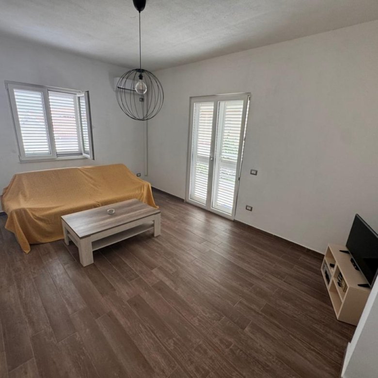 Modern living room in Ulcinj, Montenegro with wood floors, yellow sofa, natural light; a smart real estate investment by ekosphere doo.