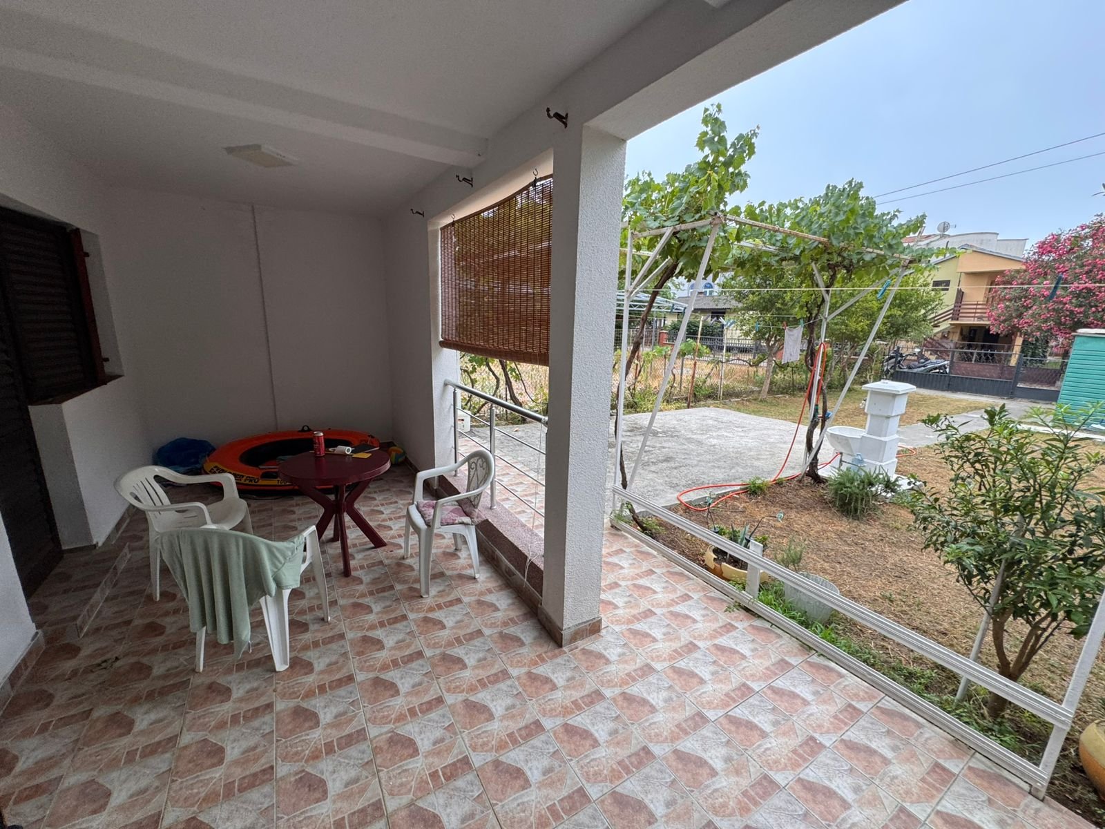 Elegant tiled patio with white columns, ideal for relaxing and entertaining in Ulcinj. Listed by Ekosphere on immorenta.me.