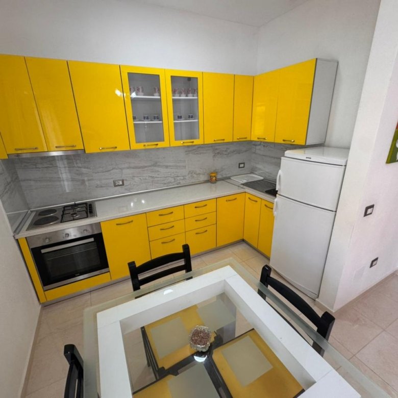 Contemporary Ulcinj kitchen with yellow cabinetry, marble backsplash, and dining area&mdash;exclusive listing on immorenta.me by ekosphere doo.