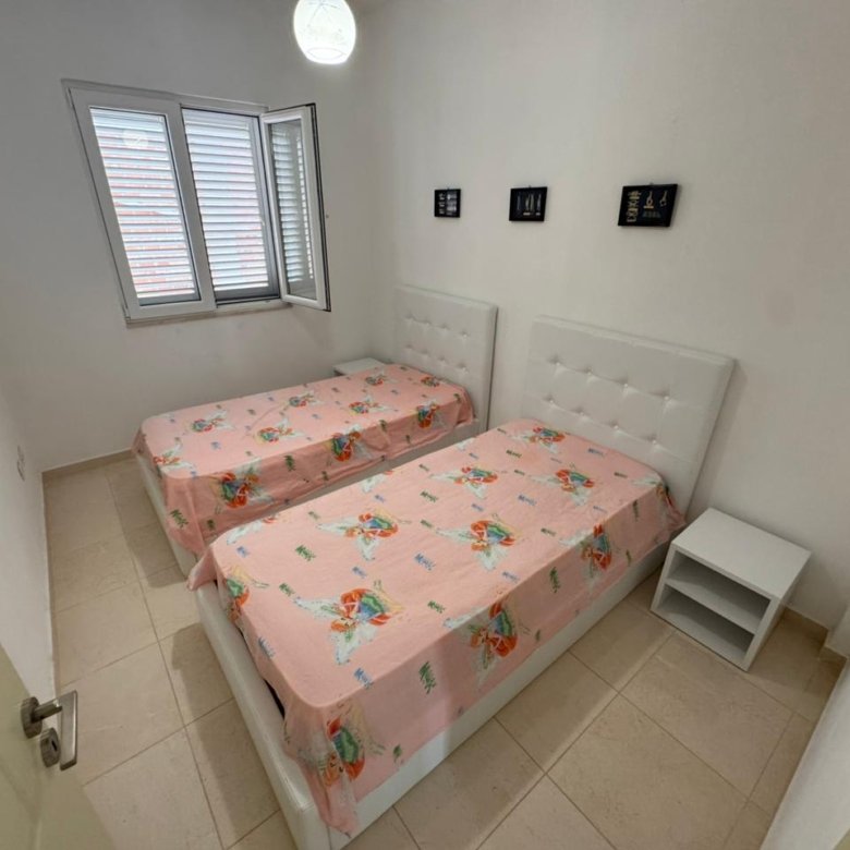 Cozy Ulcinj bedroom with twin beds, sunny window, and tiled floors&mdash;ideal Montenegro property on immorenta.me by Ekosphere doo.
