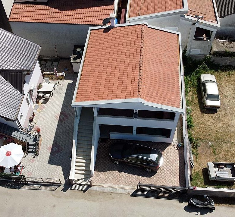 Prime investment opportunity in Ulcinj: two red-roofed homes, outdoor seating, parking, plus large lot&acirc;listed on immorenta.me.