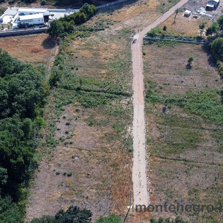 Aerial view of Ulcinj, Montenegro real estate&mdash;lush fields, scenic road, investment properties. By ekosphere doo on immorenta.me.