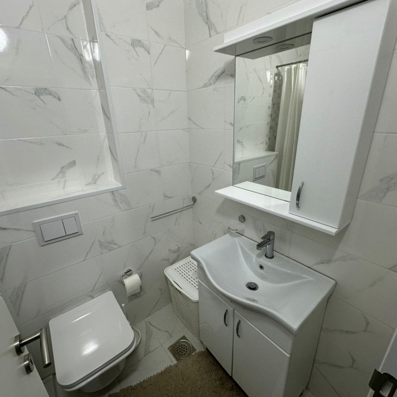 Modern bathroom in Ulcinj with marble tiles, wall-mounted toilet, elegant vanity&mdash;exclusive eco-property by ekosphere at immorenta.me.