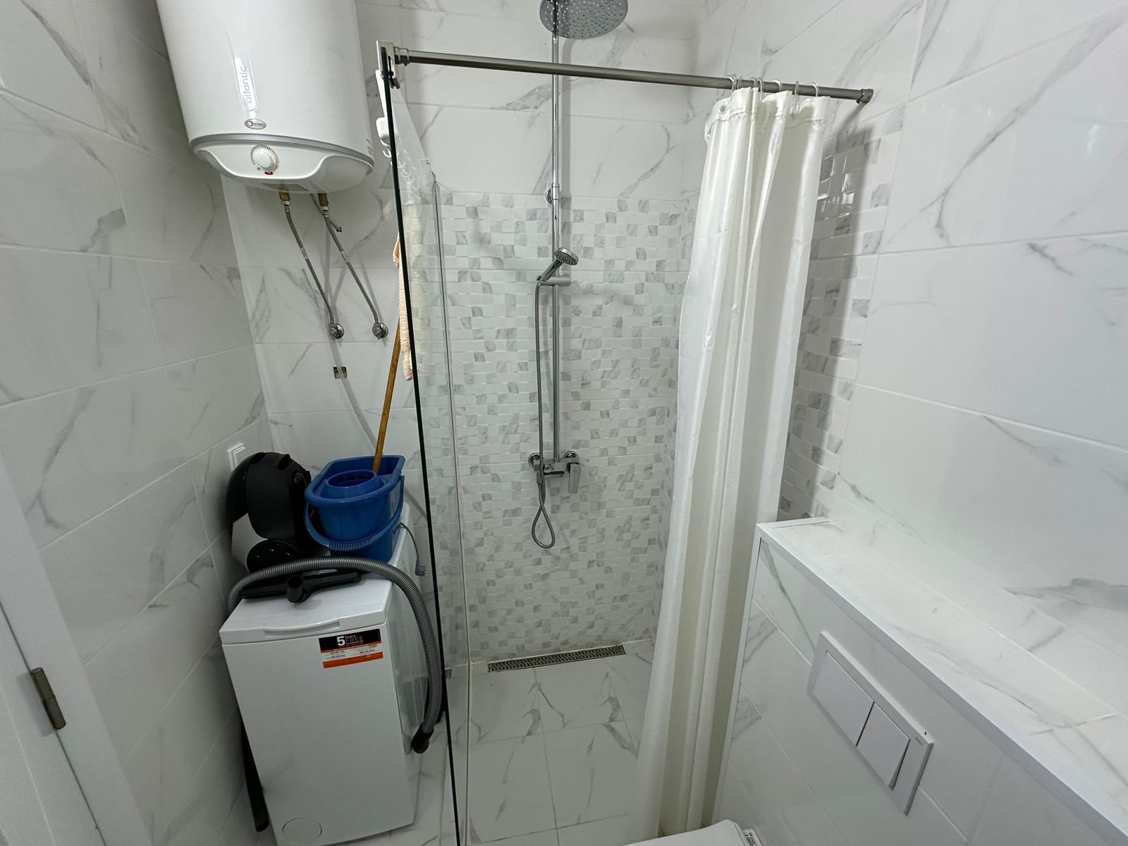 Modern, fully equipped bathroom in Ulcinj property&mdash;shower, washer, water heater, sleek tile. Invest with immorenta.me/Ekosphere DOO.