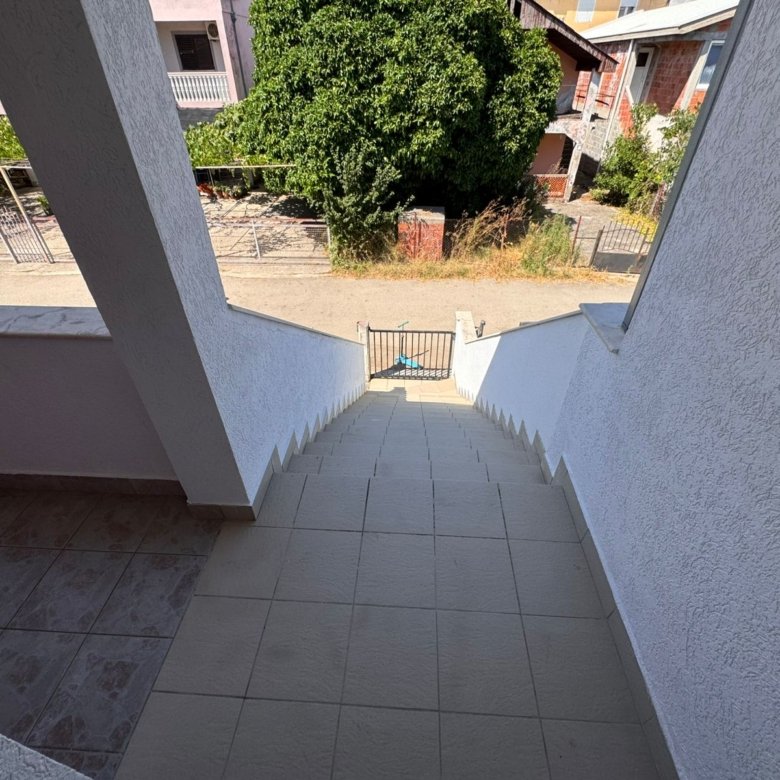 Stunning Ulcinj property: tiled stairs, secure gate, tree-lined street & white homes. A prime real estate investment via immorenta.me by ekosphere doo.