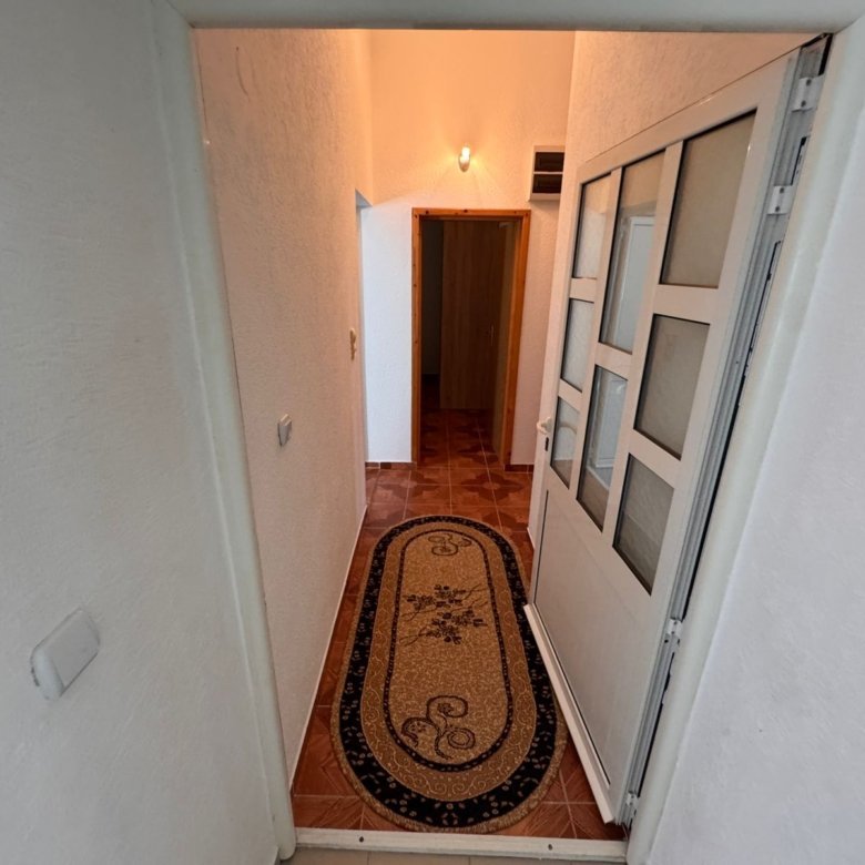 Modern Ulcinj property: bright hallway, white walls, classic brown tile floors, ideal investment. Exclusive on immorenta.me by ekosphere doo.