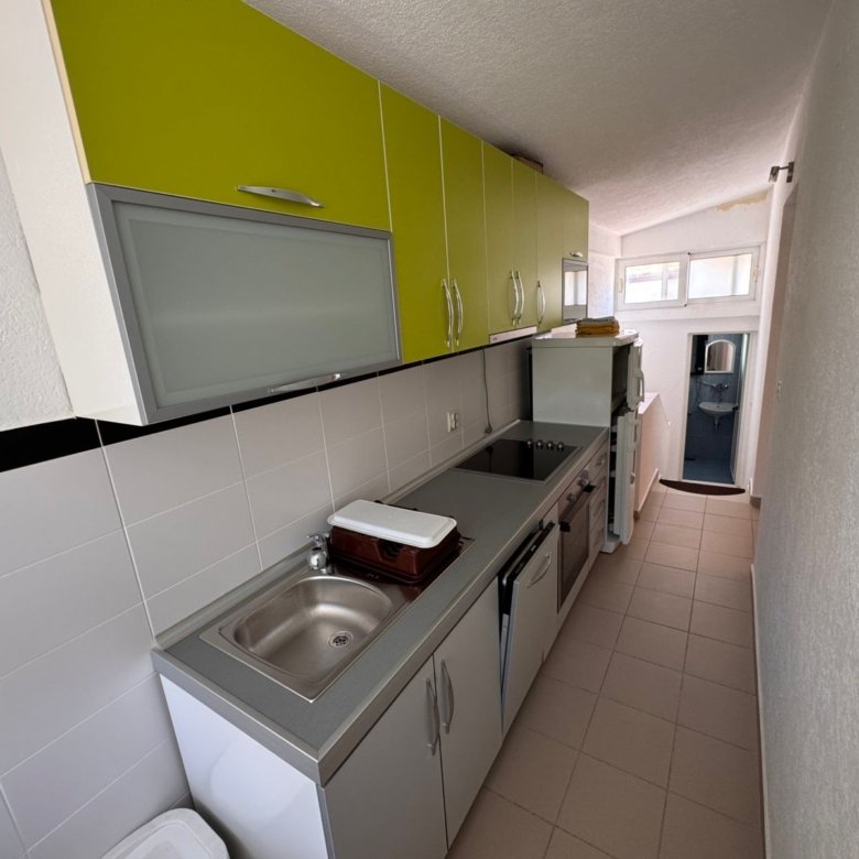 Modern galley kitchen in Ulcinj property: stylish white/green cabinets, stainless appliances, laundry zone&acirc;invest at immorenta.me by ekosphere doo.