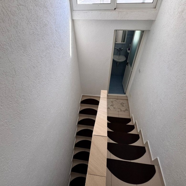 Elegant indoor staircase in a prime Ulcinj property&acirc;beige steps, non-slip mats, bath access&acirc;on immorenta.me by ekosphere doo.