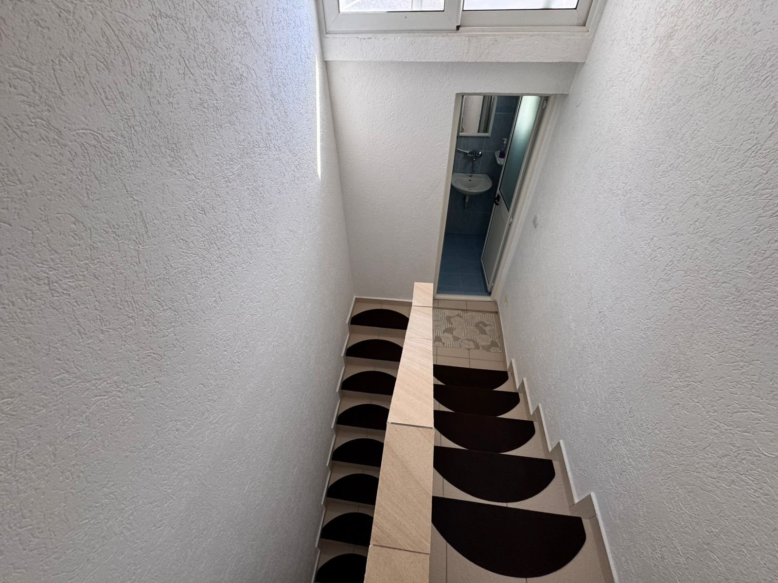 Elegant indoor staircase in a prime Ulcinj property&acirc;beige steps, non-slip mats, bath access&acirc;on immorenta.me by ekosphere doo.