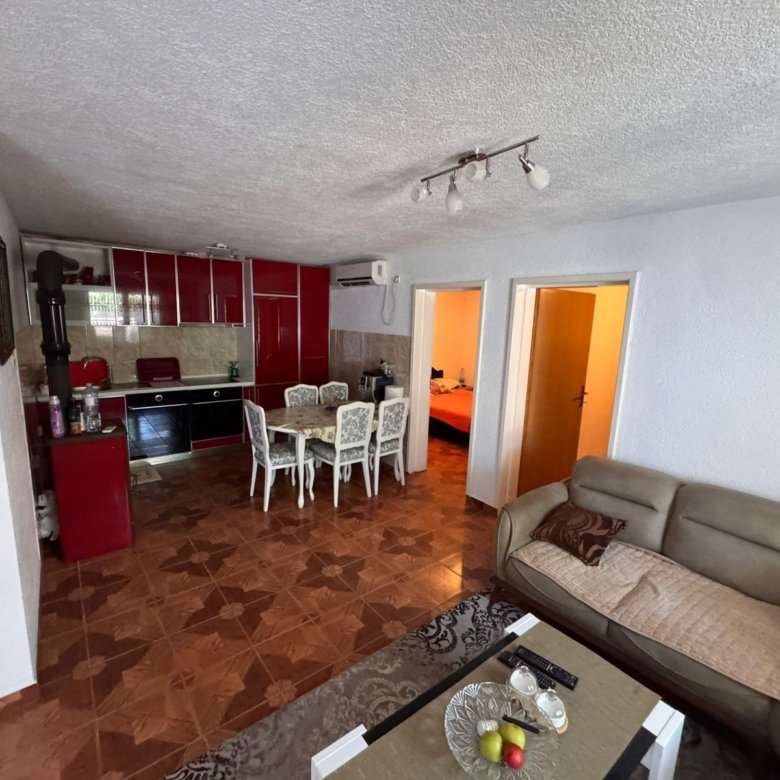 Modern Ulcinj apartment: beige sofa, stylish coffee table, open-plan kitchen with red cabinets, spacious dining&acirc;exclusive on immorenta.me by ekosphere doo.