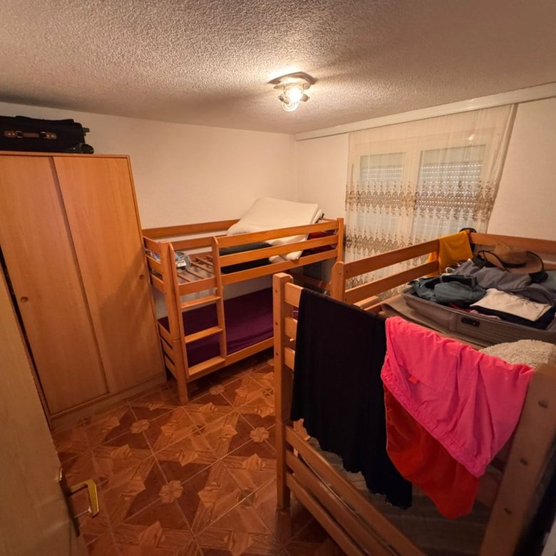Charming Ulcinj property: compact bedroom with 2 wooden bunk beds, wardrobe, stylish tiles. Discover on immorenta.me by ekosphere doo.