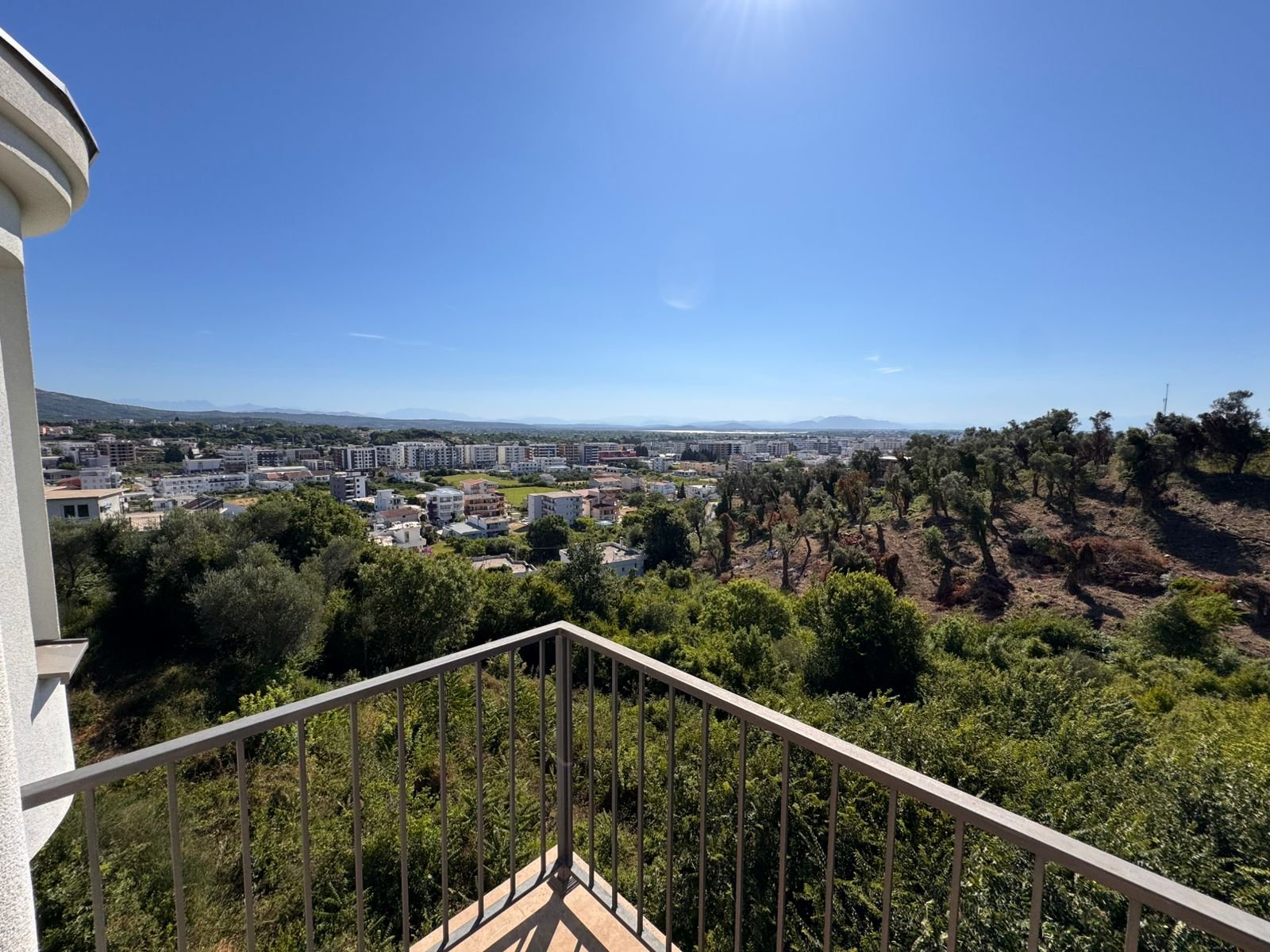 Prime balcony view of Ulcinj, Montenegro&mdash;lush hills, cityscape, sunlit skies. Invest via immorenta.me by Ekosphere doo.