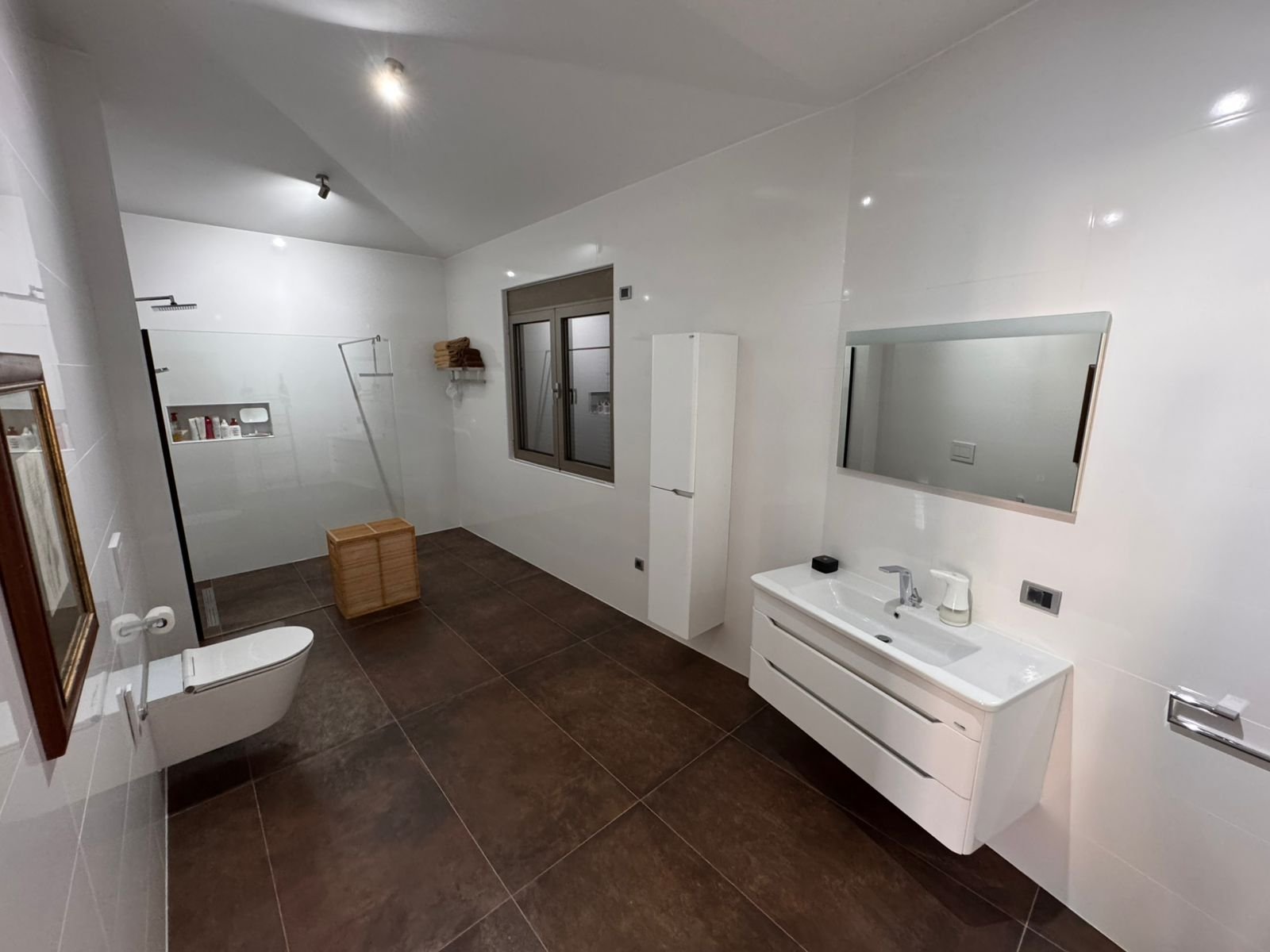 Modern Ulcinj bathroom: white walls, brown tiles, walk-in shower, mirror, vanity&mdash;prime Montenegro property at immorenta.me by ekosphere doo.