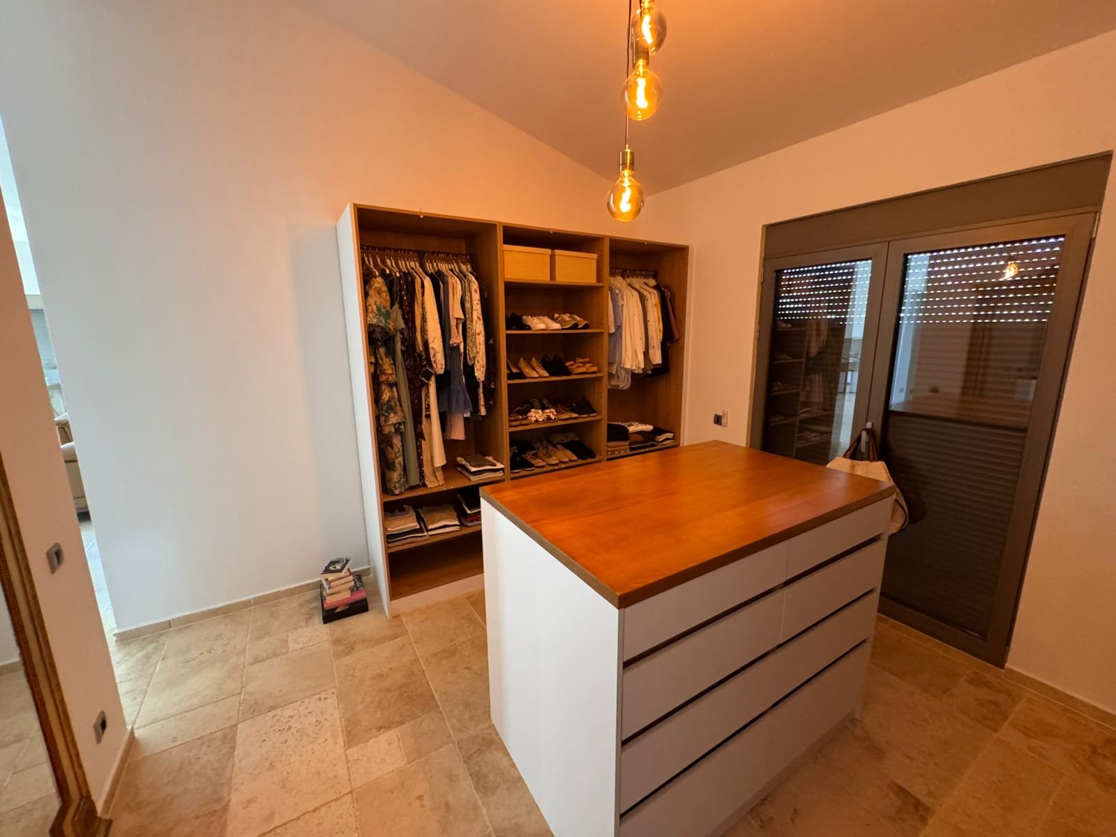 Luxury walk-in closet in Ulcinj, Montenegro: wooden island, open shelves, glass door. Exclusive on immorenta.me by ekosphere doo.