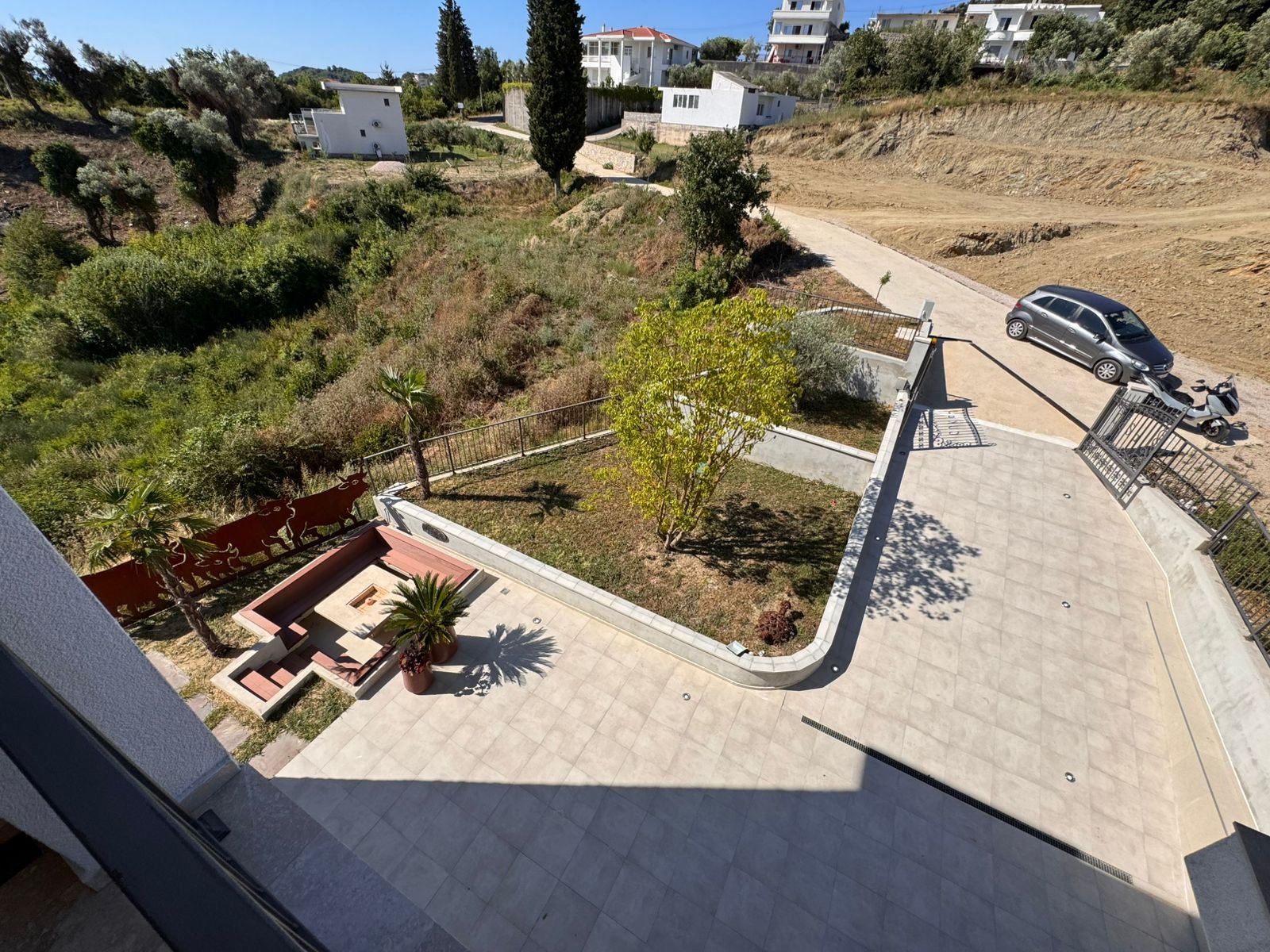 Aerial view: stylish patio, private garden, palm, and seating&mdash;prime Ulcinj property near white homes. Listed on immorenta.me by ekosphere doo.