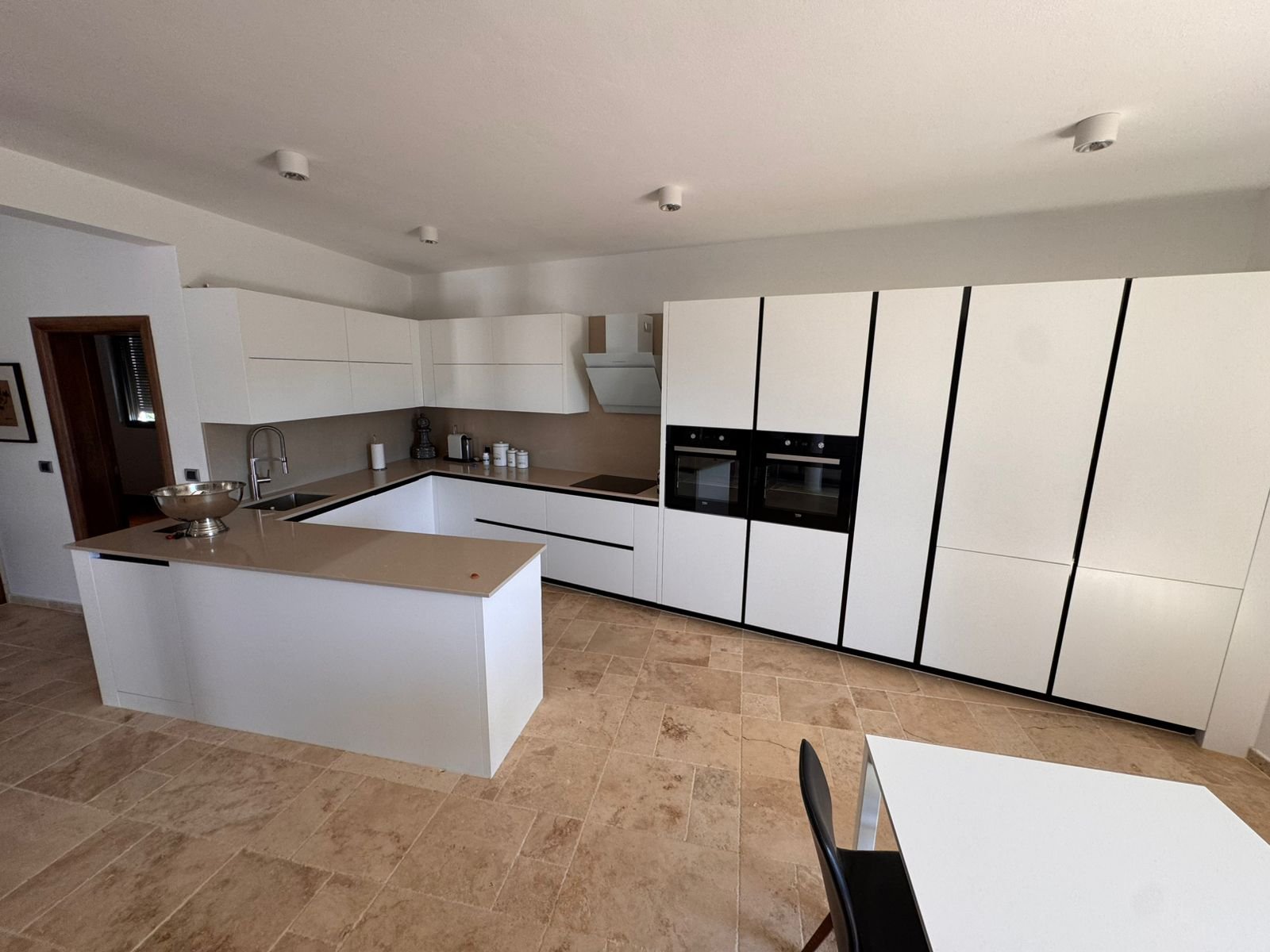 Sleek modern kitchen in Ulcinj with white cabinets, designer island, top appliances&mdash;ideal investment. Montenegro-listings.me by Ekosphere.