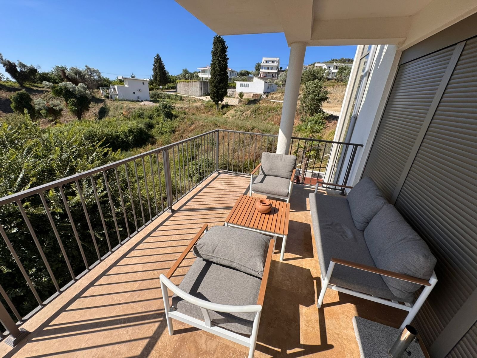 Modern balcony with stylish outdoor seating and coffee table, boasting panoramic Ulcinj views&mdash;prime Ekosphere doo investment via immorenta.me.