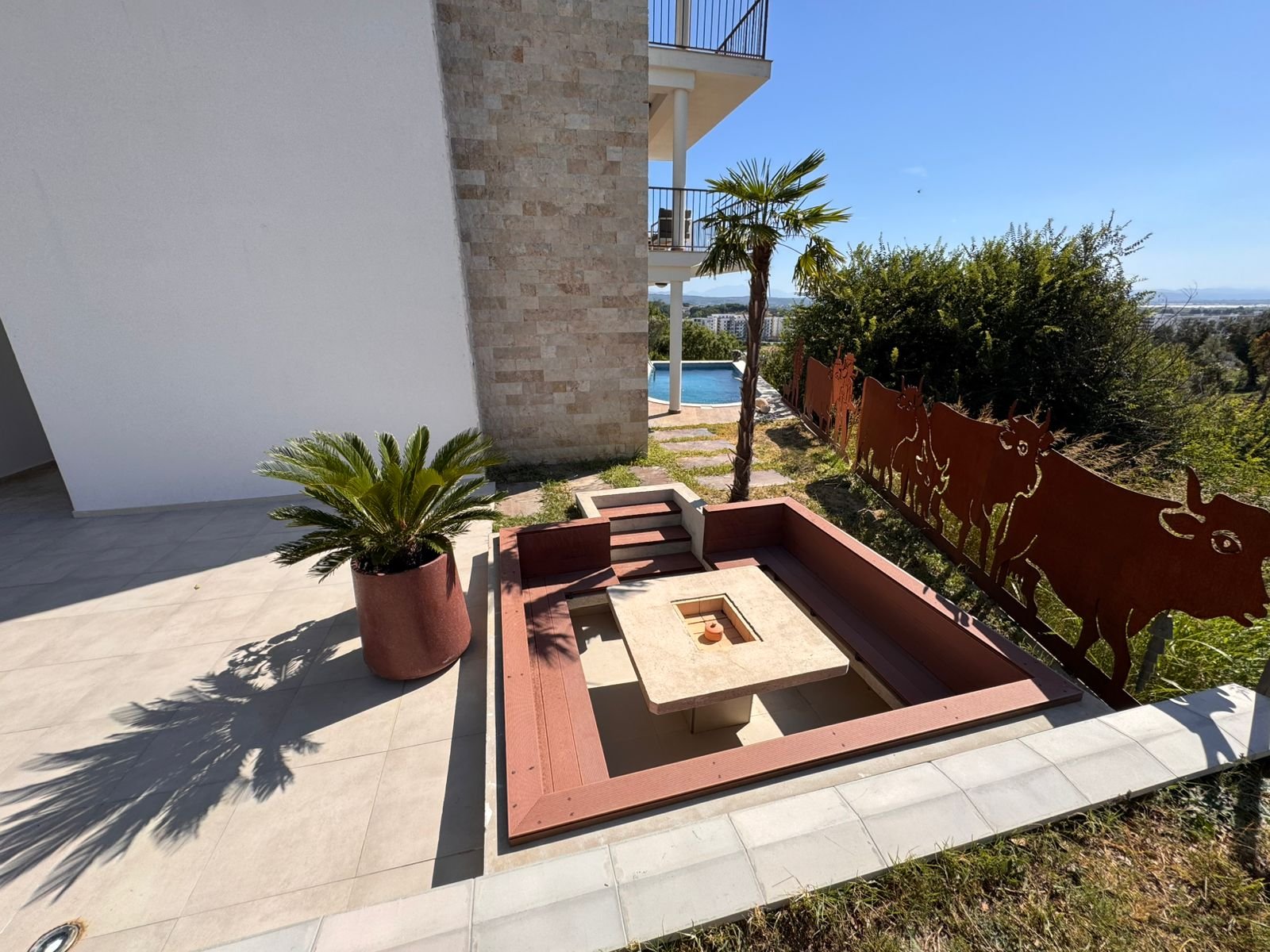 Stunning sunken fire pit with built-in seating by pool in Ulcinj Montenegro&mdash;premium real estate by Ekosphere, immorenta.me.